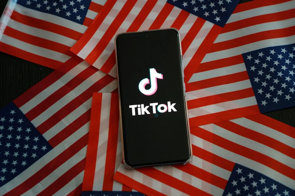 TIKTOK LOGO ON AN SMARTPHONE UPON USA FLAGS